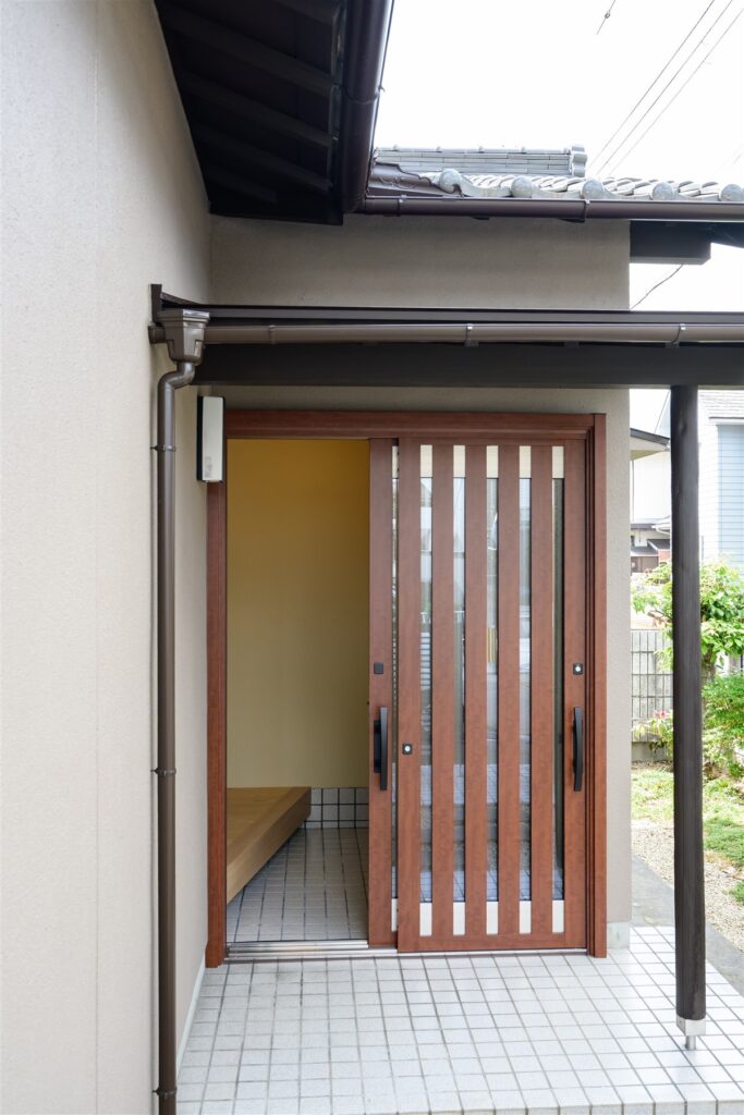木目調の玄関引き戸を取り付けた住まいの外観